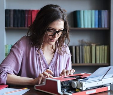 brunette-mature-woman-journalist-eyeglasses-typing-typewriter-indoors_171337-19235